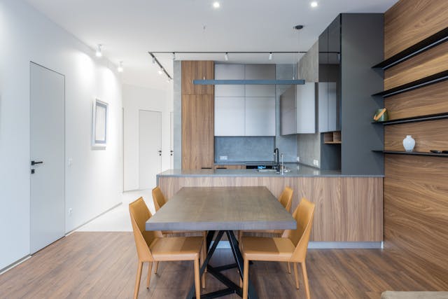 the interior of a modern apartment with stone counters and wooden cabinets